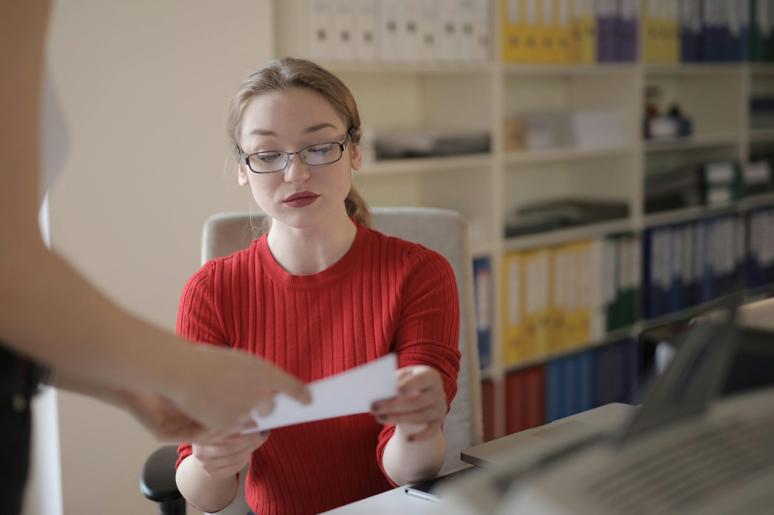 Person in an office takes a piece of paper from someone off camera.