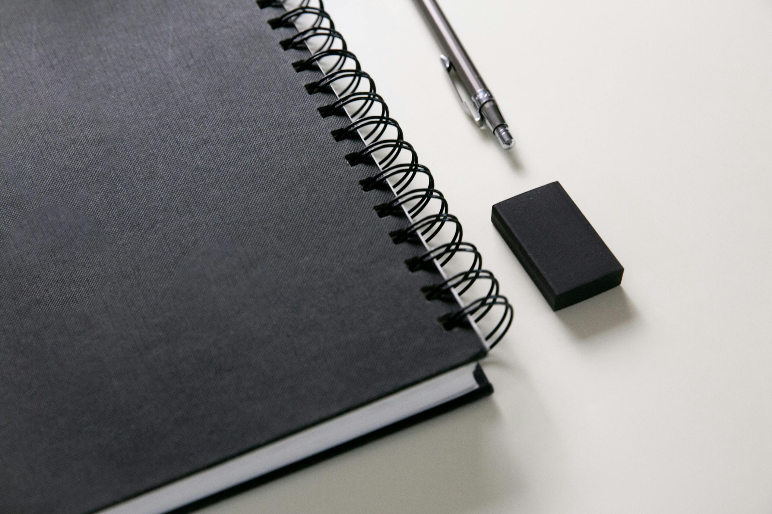 Business materials; black notebook, eraser, and pen